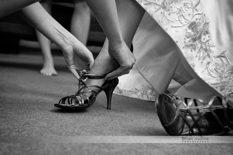 bride putting on wedding shoes