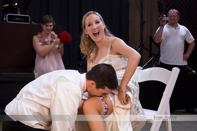 groom removing garter with teeth